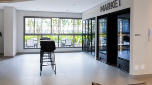 A modern interior with a large window, a bar area, and a 'MARKET' sign.