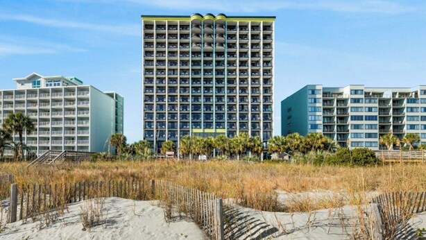 Ein Hochhaus-Hotel mit mehreren Etagen, einem zentralen Atrium und Blick auf den Strand.