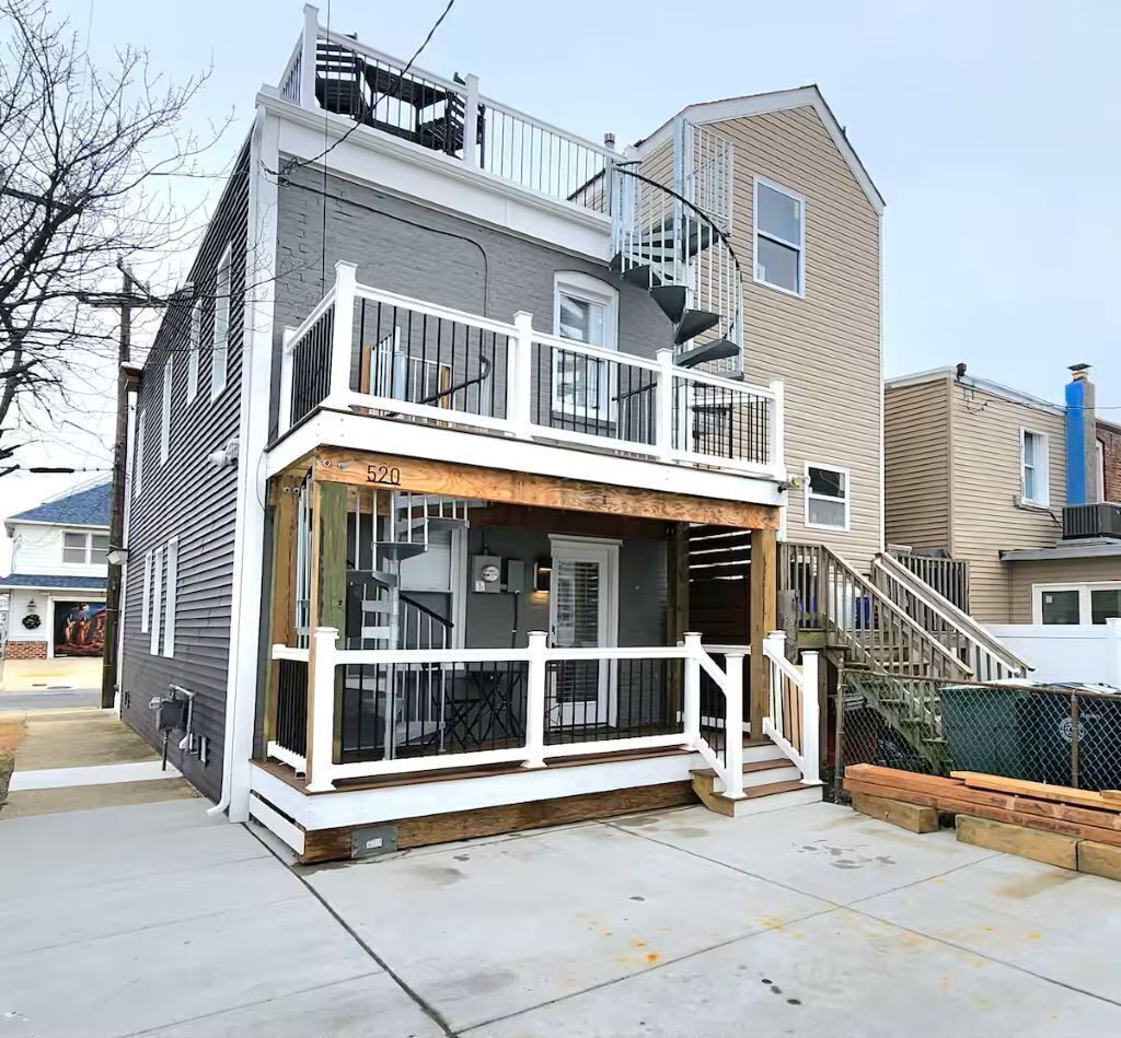 A two-story building with a balcony, a visible staircase, and a number '520' on the front.