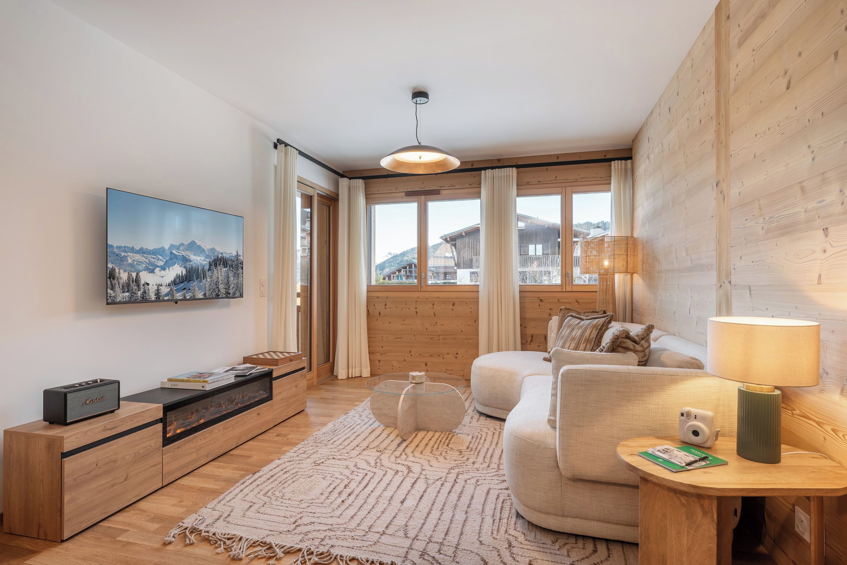 Una sala de estar moderna con chimenea, un sofá, una mesa de centro y un televisor montado en la pared.
