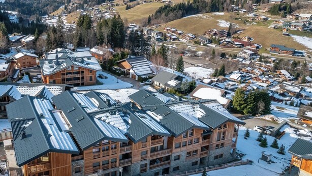 A ski resort with wooden buildings, snow-covered roofs, and a mountainous backdrop. - Kandahar – Warm Alpine Retreat in Les Gets (Les Gets)