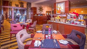 Un hall d’hôtel comprenant un comptoir d’accueil, un espace buffet et des coins salon.