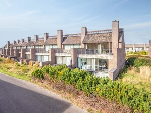 A row of modern brick houses with large windows and balconies, surrounded by greenery. - 4 Star Holiday Home in Romo (Rømø)