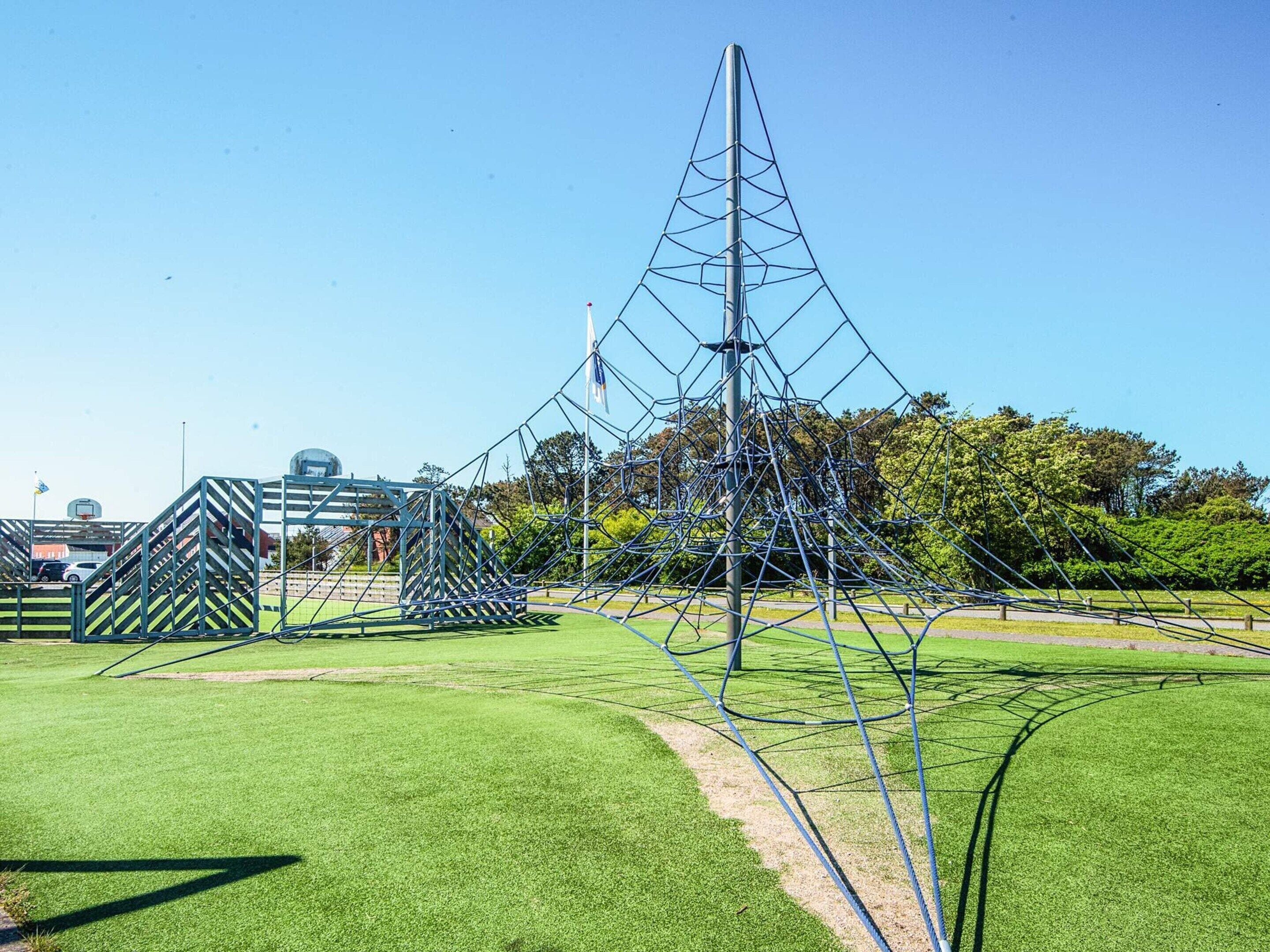 A sports field with a large metal structure, possibly for climbing or sports.