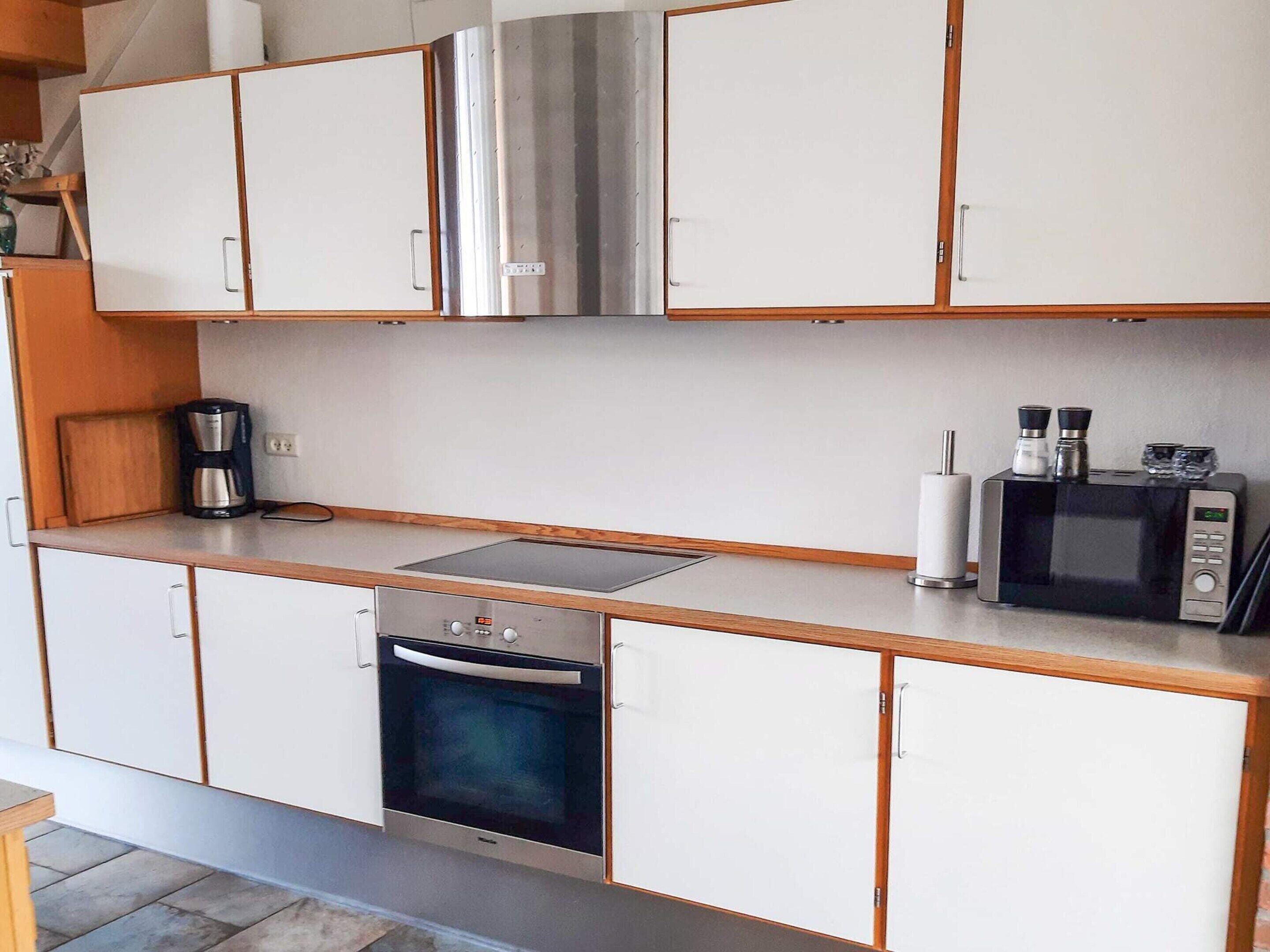 A compact kitchen with a built-in oven, a microwave, and a coffee maker.