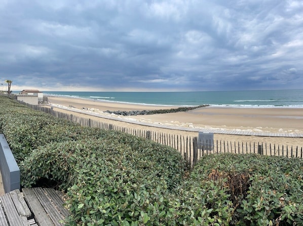 A beach with a wooden fence, a rocky breakwater, and a view of the ocean. - "La Cabane" Studio Le P’ti Chiffon with Shared Pool, Wi-Fi, and Air Conditioning (Lacanau)
