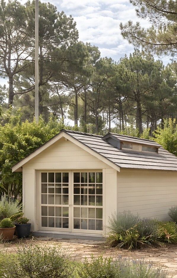 Un pequeño edificio de una sola planta con techo a dos aguas y ventanas grandes.