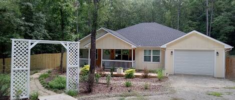 A single-story house with a front porch, a garage, and a wooden deck.