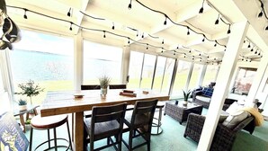 A dining area with a wooden table, chairs, and a view of the water.