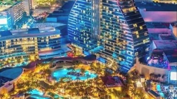 A modern hotel with a unique guitar-shaped design, featuring multiple floors and a rooftop pool area. - Spacious, Beautiful Studio in Peaceful Miramar with Refreshing Ac (Miramar)