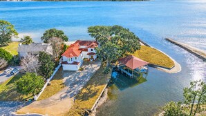 A waterfront property with multiple houses, a dock, and a clear view of the ocean. - Private Water Access | Heated Pool | Kayaks (Mary Esther)