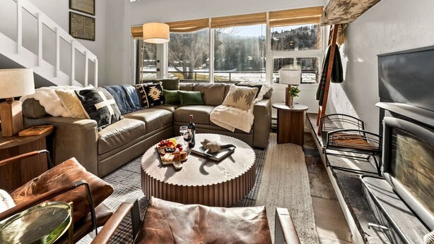 A modern living room with a large window, a fireplace, and a cozy seating area. - Eagle-Vail Family Retreat | Pool, Golf & Trails (Beaver Creek)