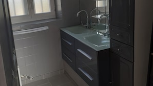 Un bagno moderno con uno specchio grande, un lavabo e un water.
