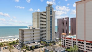 A hotel with multiple floors, a central tower, and a beach view. - NEW fireplace and Christmas Decor starts Nov 1! (Myrtle Beach)