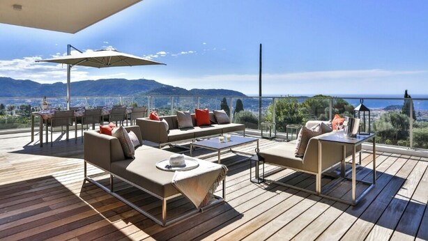 A spacious outdoor deck with a sofa, chairs, and a table, overlooking a scenic view of mountains and the sea. - Le 120m2 - luxury, swimming pool, terrace and garage (Nice)