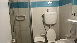 Une salle de bain avec des toilettes, un lavabo et une douche.