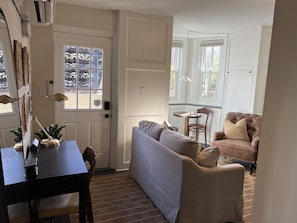 A cozy living room with a dark wooden table, a grey sofa, and a brown leather armchair. - Charming 1-bedroom apartment in Dupont Circle Rowhome in Washington DC (Washington)