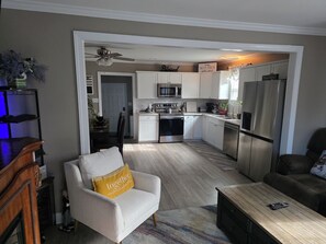 A modern kitchen with white cabinets, stainless steel appliances, and a ceiling fan. - Beautiful and cozy 2 bedroom cottage in quite area of Eden. Fully fenced. (Eden)