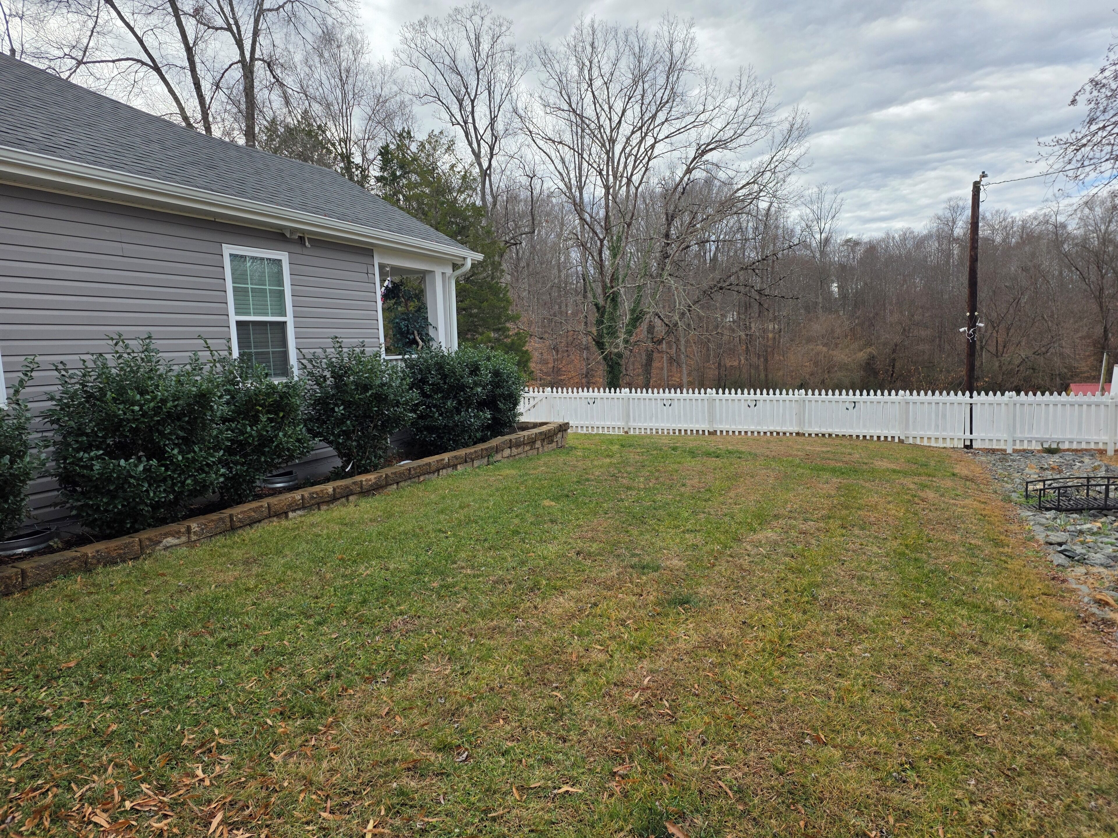 A residential property with a house, a white picket fence, and a grassy yard.