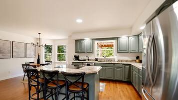 {Kitchen} Spacious and fully equipped for group cooking, with generous prep space, bar seating, and room for everyone to gather while meals come together.