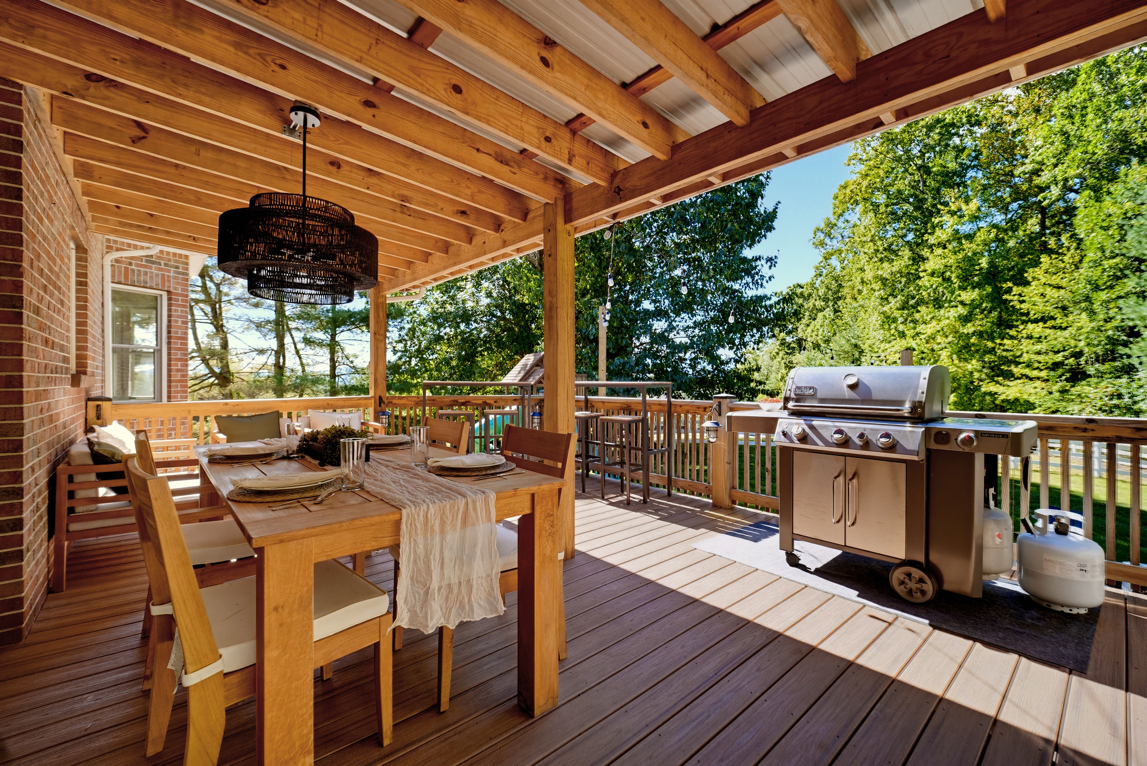 {Covered Deck + Grill} Cook, dine, and unwind outdoors on the covered deck with a gas grill, plenty of seating, and mountain air all around you.