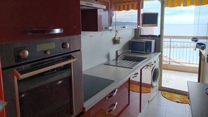A kitchen with a built-in oven, microwave, and sink. - Sea view apartment (Saint-Raphaël)