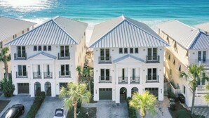 A row of white buildings with grey roofs, a paved driveway, and palm trees. - Frangista Sunset | Private Beach | Pools | Updated | Beach Gear | 3 Patios (Miramar Beach)