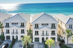 A row of white buildings with grey roofs, a paved driveway, and palm trees. - Frangista Sunset | Private Beach | Pools | Updated | Beach Gear | 3 Patios (Miramar Beach)