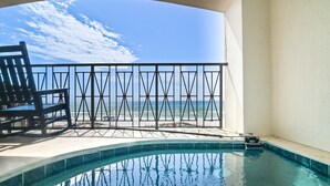 A pool area with a view of the ocean, a chair, and a railing. - Frangista Sunset | Private Beach | Pools | Updated | Beach Gear | 3 Patios (Miramar Beach)