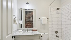 Un baño con tocador blanco, inodoro, bañera y ducha.