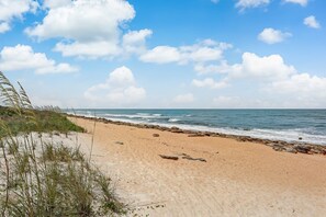 Ein Strand mit felsiger Küste und brechenden Wellen.