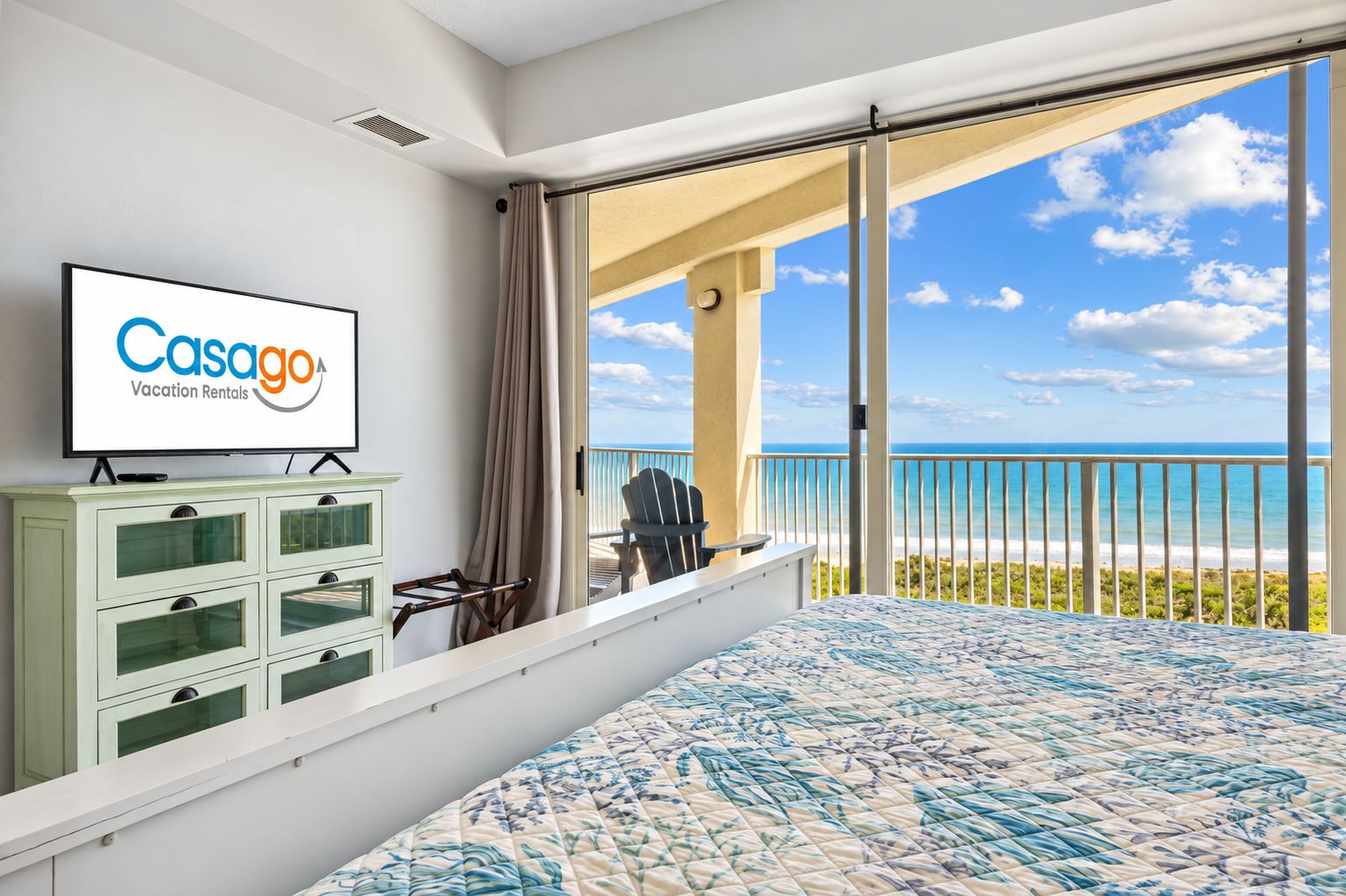 Une chambre d’hôtel avec un lit, une télévision, un bureau et une vue sur l’océan.