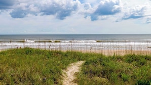A beach with a path leading to the shore, grassy dunes, and the ocean. - Modern 6BR Beach Retreat w/ Private Pool (Oak Island)