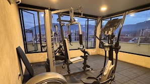 Ein Fitnessraum mit Cardiogeräten, darunter ein Crosstrainer und ein Ergometer, sowie ein Kraftgerät.