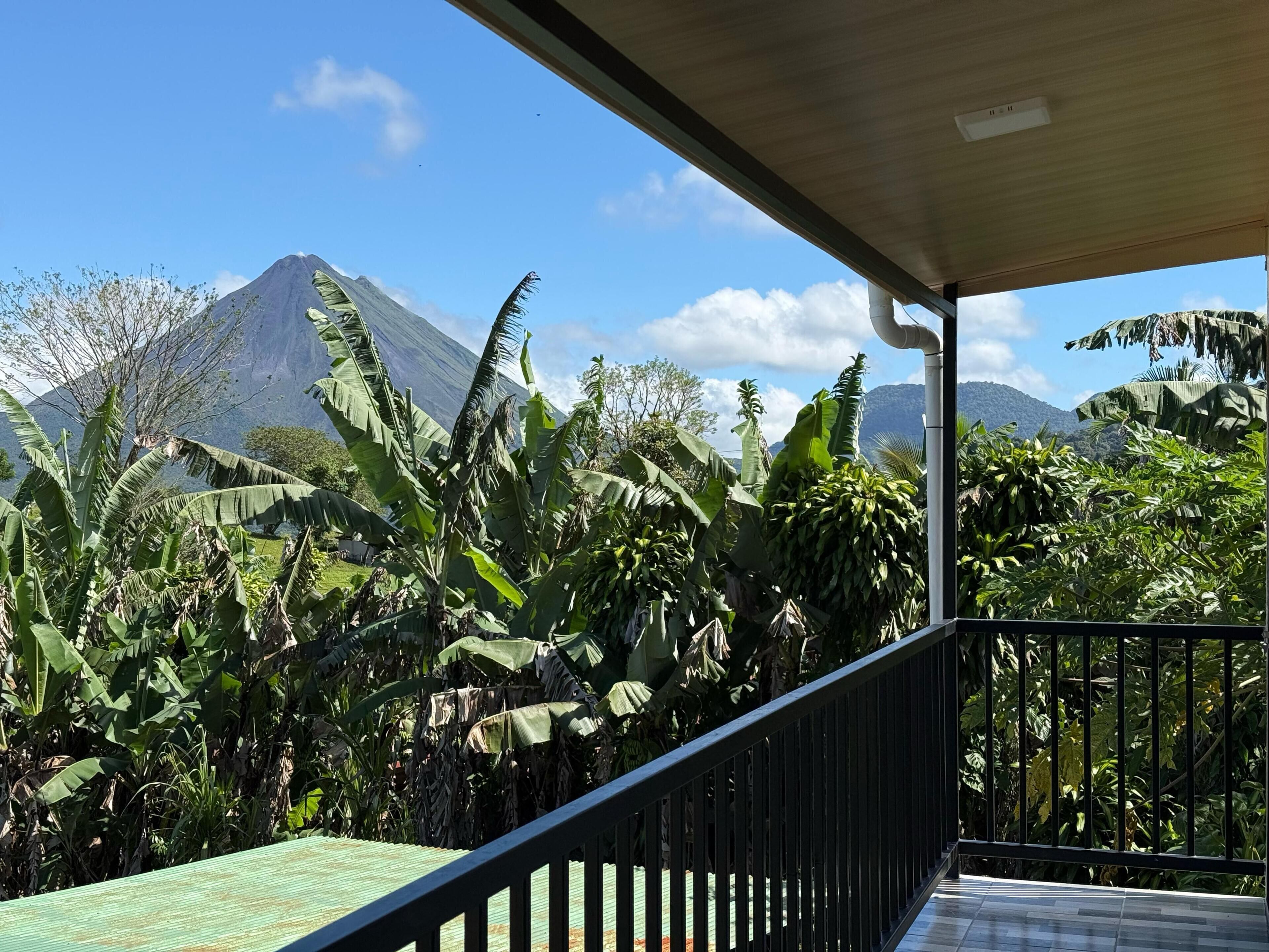 A balcony with a view of a mountain and lush vegetation.