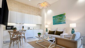A modern living space with a kitchen, dining area, and seating area. - Genteel Home Mendoza Rios III (Seville)