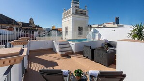 A rooftop terrace with a pool, outdoor seating, and a white building with a dome. - Genteel Home Mendoza Rios III (Seville)