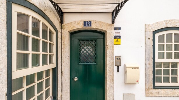 A building with a green door, a number 13 sign above it, and a security keypad on the wall. - Guestready - The Corner 2D (Lisbon)