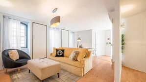 A modern living room with a sofa, a chair, a coffee table, and a lamp. - Guestready - The Corner 2D (Lisbon)