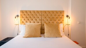 A hotel room with a tufted headboard, two bedside lamps, and two pillows. - Guestready - The Corner 2D (Lisbon)