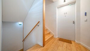 A staircase with wooden handrails and a white door with a 2D sign. - Guestready - The Corner 2D (Lisbon)