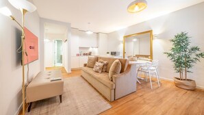 Un salon moderne comprenant un canapé, une table basse, un téléviseur et un coin repas avec une table et des chaises.