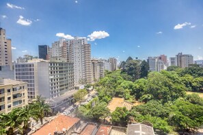 Une vue urbaine avec de hauts immeubles, un grand parc au centre et un ciel dégagé.
