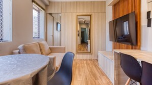 A compact, modern room with a dining table, chairs, a TV, and a wooden panel wall. - Moderno Est dio Frei Caneca a 1 km da Av Paulista (São Paulo)