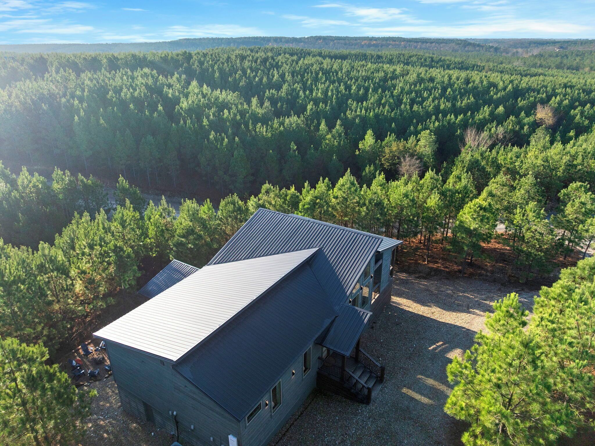 En hytte med skrå tag, omgivet af tæt skov.