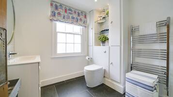 Une salle de bain moderne équipée de toilettes, d’un lavabo et d’un porte-serviettes.