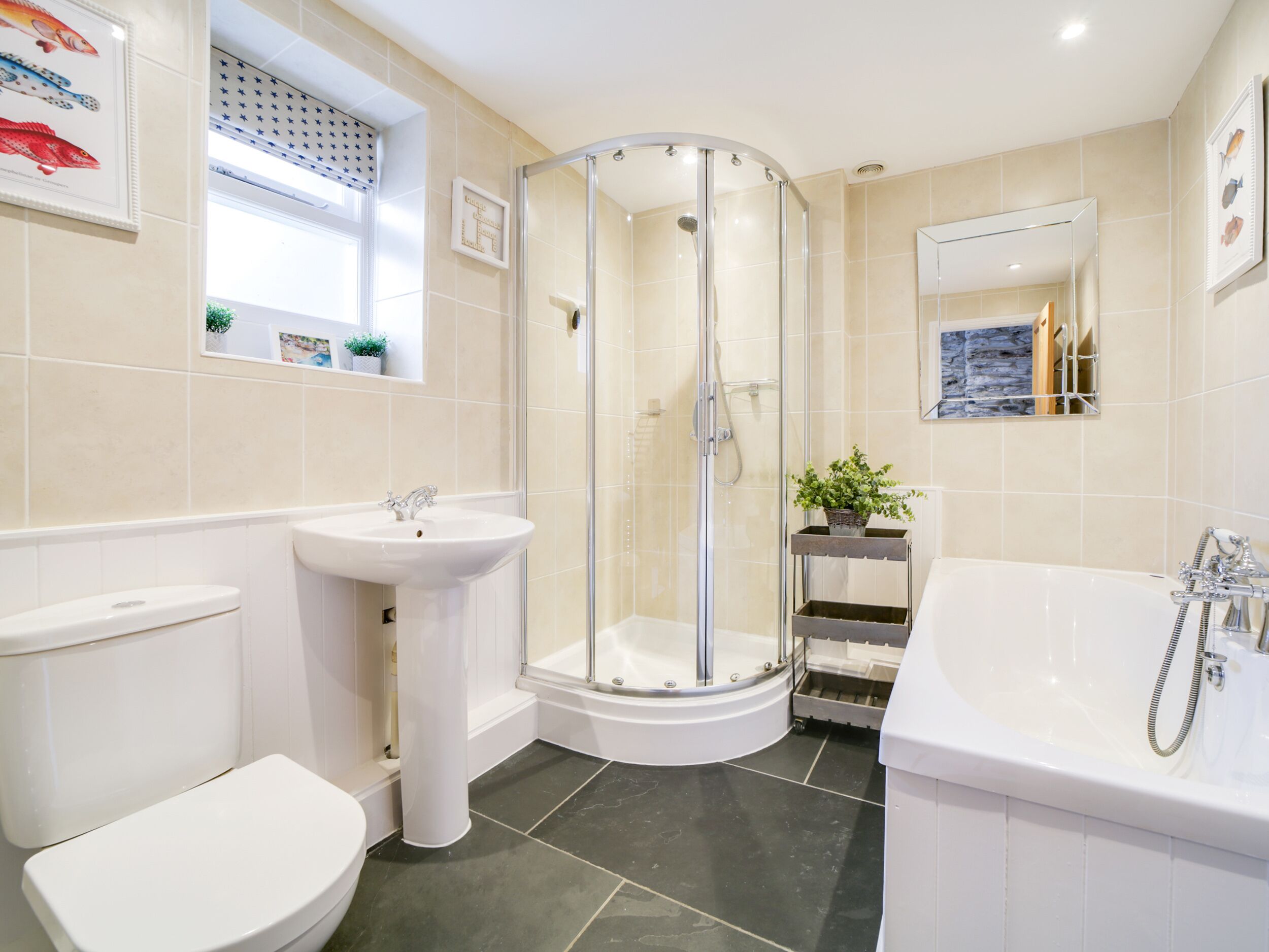 A modern bathroom with a glass-enclosed shower, a white sink, a toilet, and a bathtub.