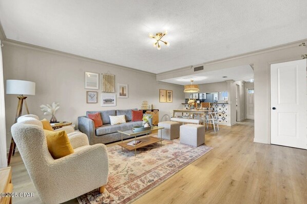 A spacious living room with a sofa, armchair, coffee table, and a dining area with a table and chairs. - Cozy home in amazing Laguna Beach, Panama City Beach, 500 ft from beach. (Panama City Beach)