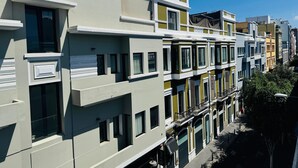 Una hilera de edificios de varios pisos con balcones, ventanas amplias y un cielo despejado.