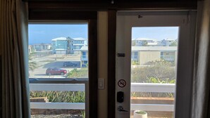 A view from a door to a residential area with houses, a road, and a no parking sign. - BSI 103--Studio with Ocean View, Pool, Walk to the Beach, Dogs OK! (Port Aransas)